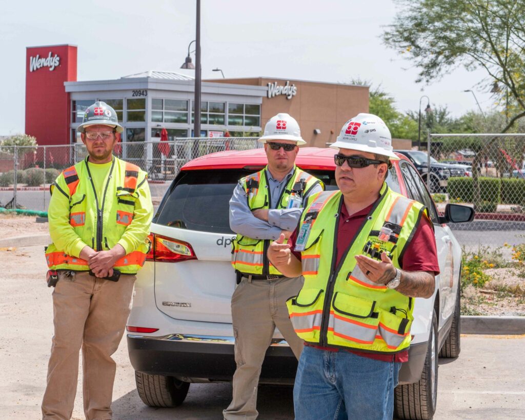 Three men standing in front of a new suv.