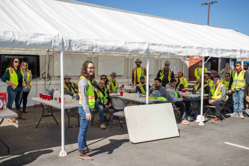 A group of people standing in front of a tent, including Danielle Puente who has been promoted to President and CFO.