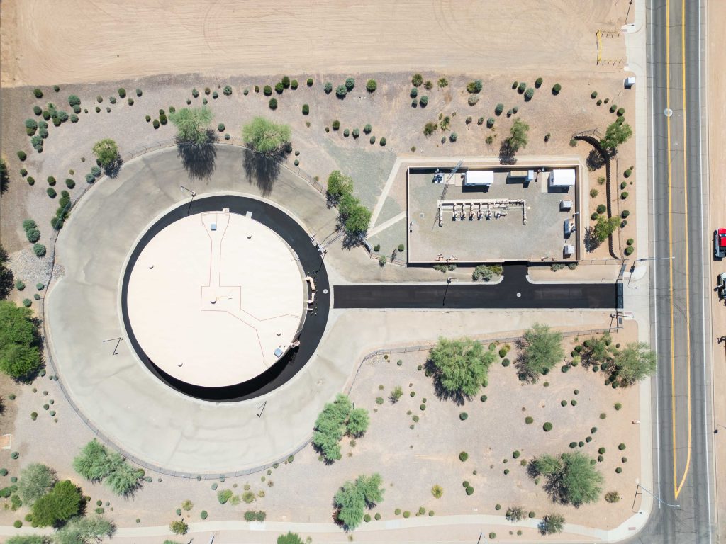 Aerial view of the Chandler Tank Rehab, showcasing a large circular water tank and adjacent utility facility surrounded by desert landscaping, nearby roads, and sparse vegetation.